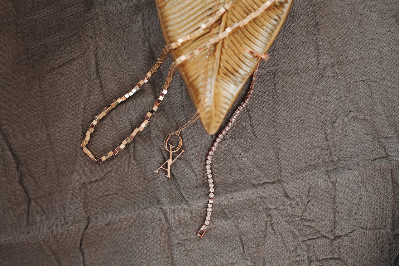 Glamorous gold jewelry displayed on creased fabric, highlighting luxury design.
